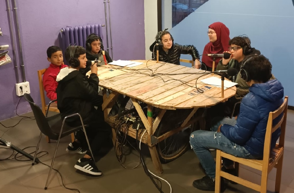 Infants de la Biblioteca Montseny realitzant el taller de ràdio dirigit per Ràdio Clota